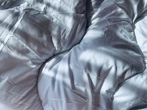 Draufsicht auf weiße Bettdecke zerknüllt zur Morgenzeit - Foto, Bild