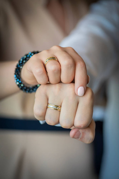 Hands of the bride and groom with engagement rings, clenched in fists - Photo, Image