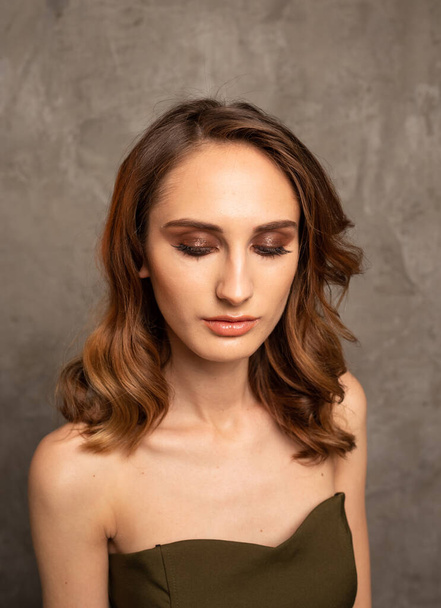 девушка модель с ярким макияжем на сером фоне с местом для текста, Новый год макияж - Фото, изображение