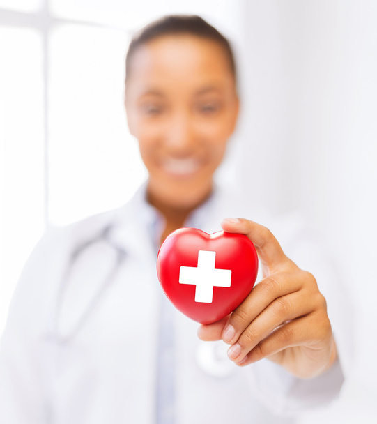 female doctor holding heart with red cross symbol - Valokuva, kuva