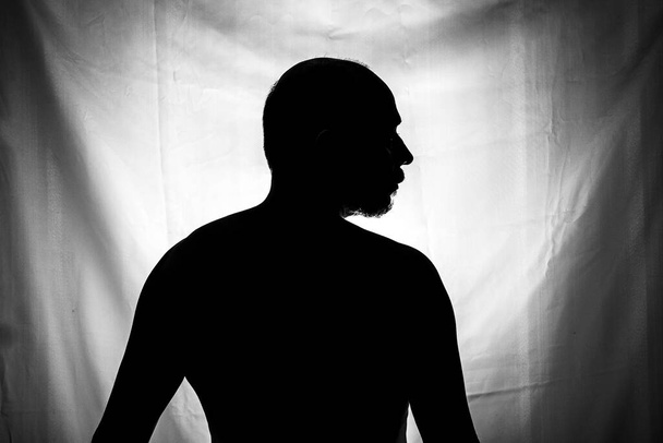 Zwart-wit portret in Silhouet van een man tegen witte achtergrond. Salvador, Bahia, Brazilië. - Foto, afbeelding