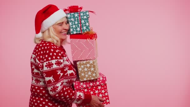 Starší babička žena ve vánočním svetru drží mnoho dárkových krabic Nový rok dárek nákupní prodej - Záběry, video