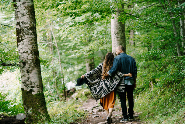 抱擁の男と女が緑の公園を歩いている。バックビュー - 写真・画像