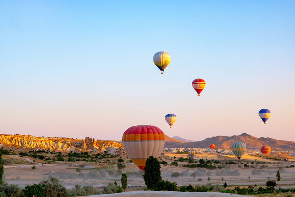 Cappadocia background. Hot air balloons in Cappadocia at sunrise. Ballooning activities in Goreme. - Foto, afbeelding
