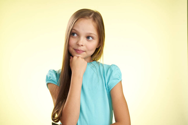 cheerful little girl with long hair close-up studio posing - Fotó, kép