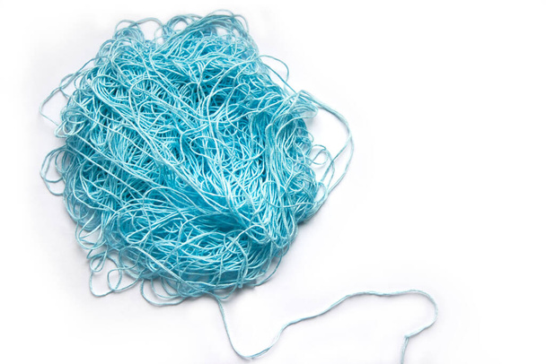 The concept of brainstorming. A tangle of mint, blue cotton threads, needlework yarn on a white background. - Photo, Image
