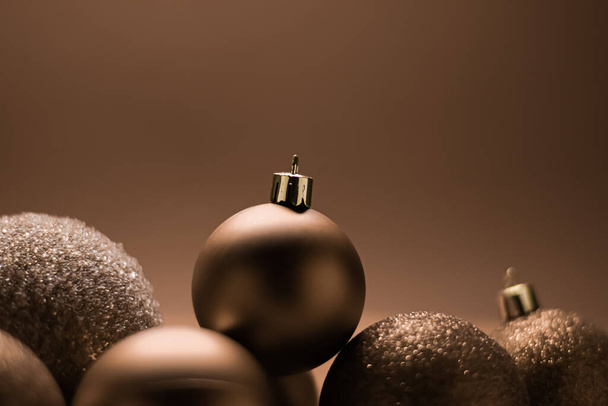 Christmas holiday and festive decoration concept. Golden baubles on beige background - Photo, Image