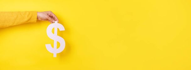 dollar symbol in hand over yellow background, panoramic layout - Foto, Imagem
