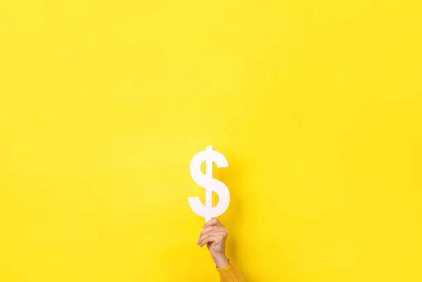 mano celebración dólar símbolo sobre fondo amarillo - Foto, imagen