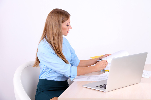 Business woman with documents at her workplace - Foto, afbeelding