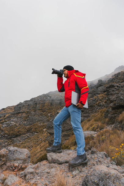 fotógrafo de viajes con cámara y portátil en las montañas - Foto, Imagen