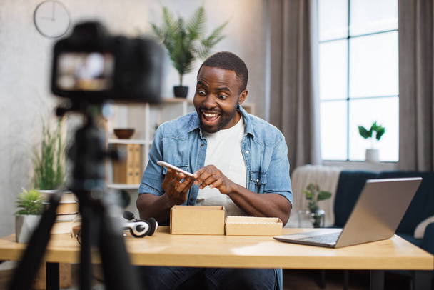 African man filming video while unpacking new smartphone - Fotografie, Obrázek