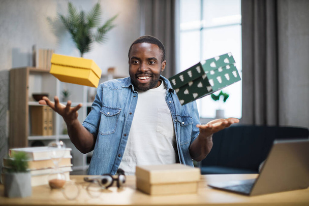 African influencer taking fun while unpacking gift boxes - Foto, immagini