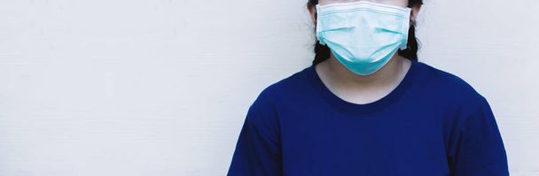 Banner panorama mladé ženy nosil modré tričko a masku na ochranu proti koronaviru nebo COVID-19. - Fotografie, Obrázek