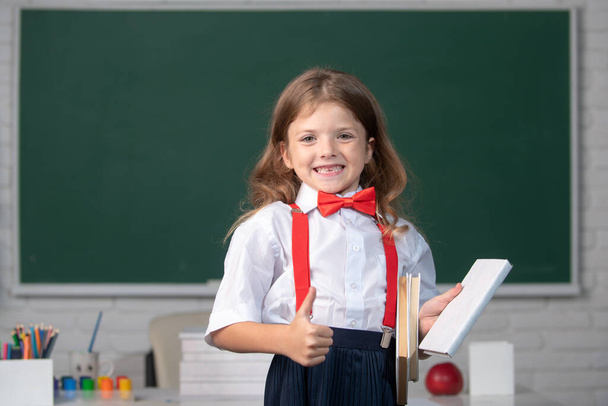 Portrait of cute, lovely, girl in school uniform in classroom. - Foto, imagen