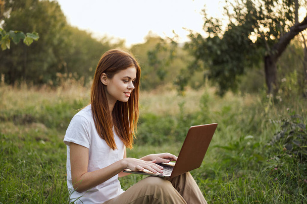 women outdoors in field with laptop leisure technology freedom - Foto, imagen