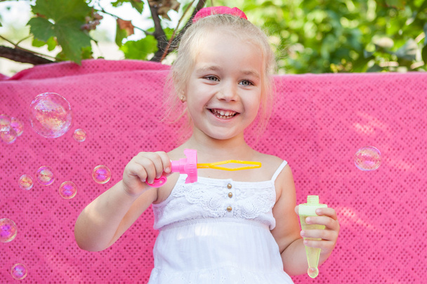 Happy little girl with soap bubbles - Foto, imagen