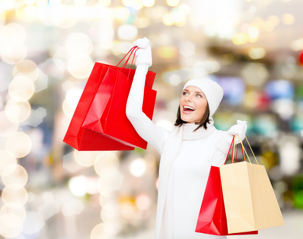 smiling young woman with red shopping bags - Foto, afbeelding