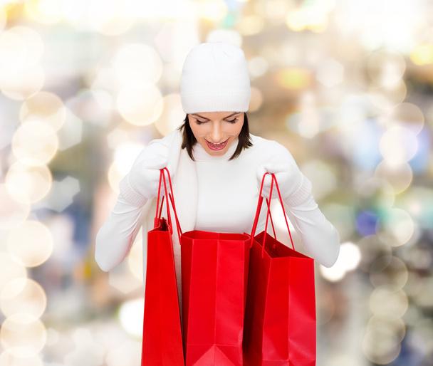 smiling young woman with red shopping bags - Foto, Imagem