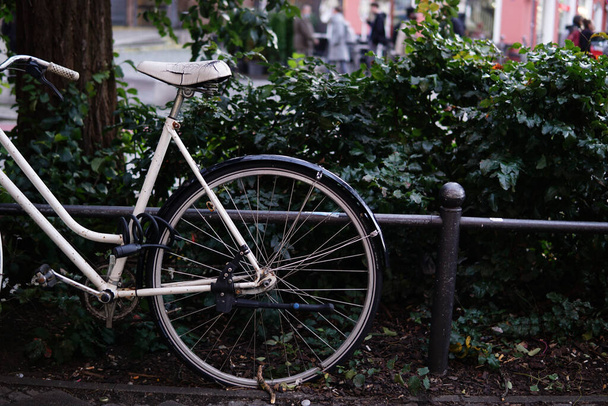 A closeup of the bicycle wheel. The bicycle parked on the street. - Foto, Imagem