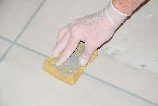 Tiler smoothing tile joints with a sponge - Photo, Image