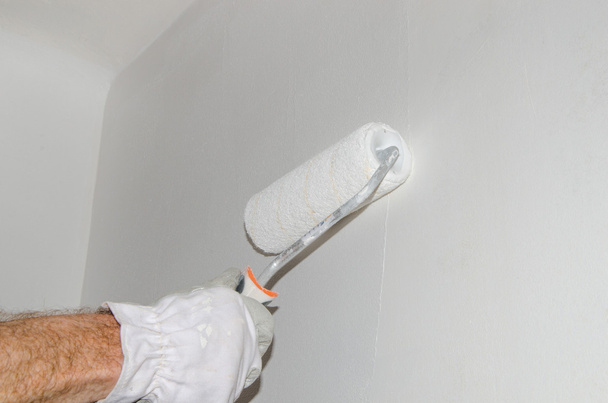 Pintar a mano una pared con un rodillo de pintura
 - Foto, Imagen