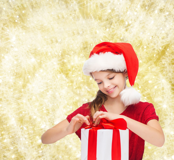 smiling girl in santa helper hat with gift box - Photo, image