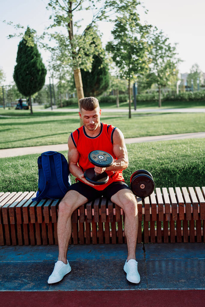 athletic man in red t-shirt in fitness park - Fotó, kép