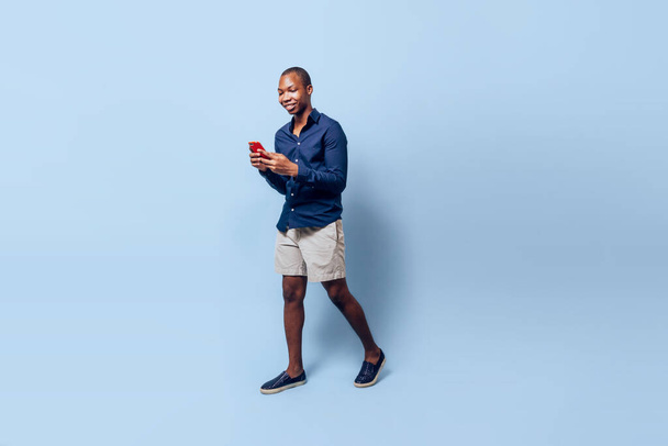 An African American man looking at his smartphone - Foto, imagen