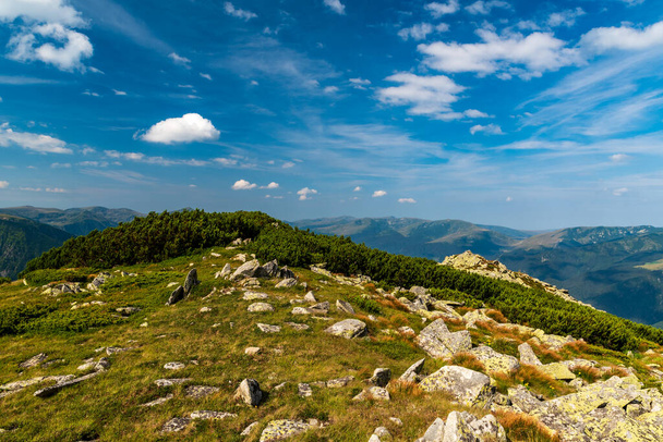 Increíble vista desde la cumbre de la colina de Varful Zlata sobre el lago Zanoaga en las montañas Retezat en Rumania con muchas colinas y cielo azul con nubes - Foto, Imagen