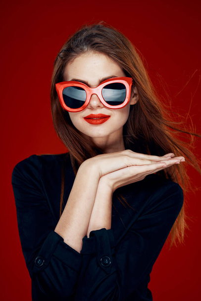 pretty woman wearing sunglasses fashion posing hairstyle red background - Zdjęcie, obraz