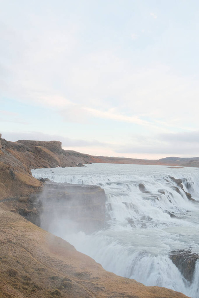 A natural view of the famous Gullfoss waterfall in Iceland under a cloudy sky - Zdjęcie, obraz