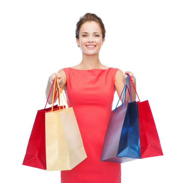 smiling elegant woman in dress with shopping bags - Foto, afbeelding