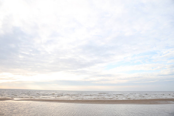 Gyönyörű kilátás a tengerre, homokkal és a Balti-tengerre. Fénykép egy meleg, felhős felhős őszi időjárás. - Fotó, kép