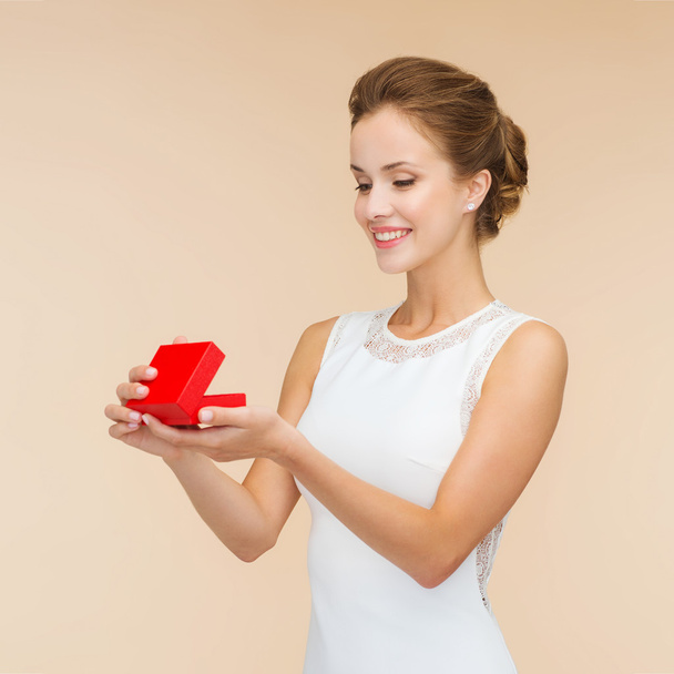 smiling woman holding red gift box - Φωτογραφία, εικόνα