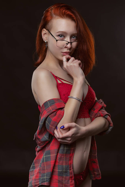 sexy gorgeous young woman in an unbuttoned shirt and red beautiful underwear posing on a black background - Valokuva, kuva