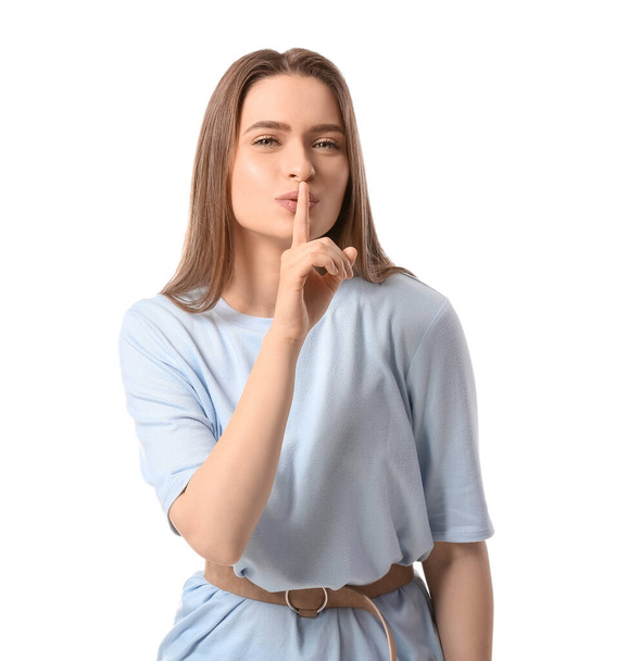 Junge Frau zeigt Schweigegeste auf weißem Hintergrund - Foto, Bild