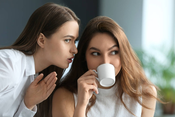 Female colleagues gossiping in office - Foto, Bild
