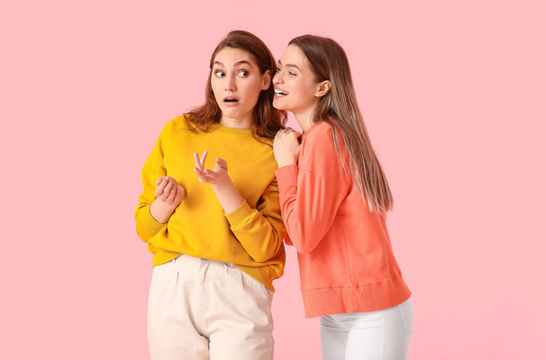 Young gossiping women on color background - Foto, Imagem