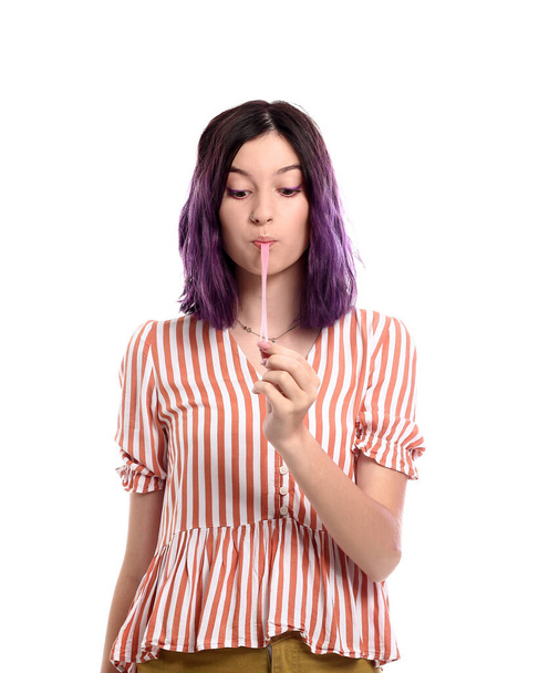 Młoda kobieta z fioletowymi włosami i gumą do żucia na białym tle - Zdjęcie, obraz