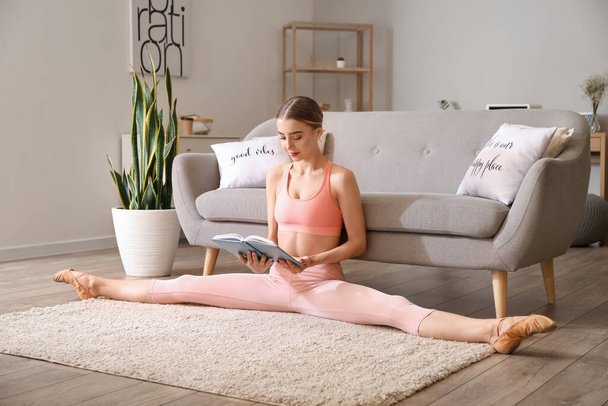 Mulher bonita ler livro enquanto fazendo perna-split em casa - Foto, Imagem