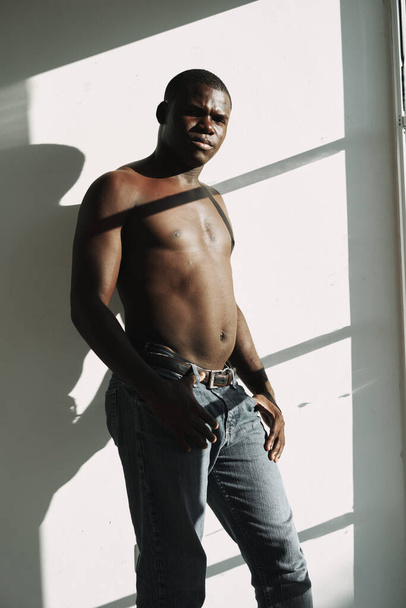 Hombre africano en jeans torso desnudo cerca de la ventana - Foto, Imagen