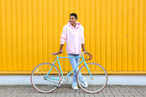 アフリカ系アメリカ人のティーン男の子とともに自転車近く黄色のフェンス - 写真・画像