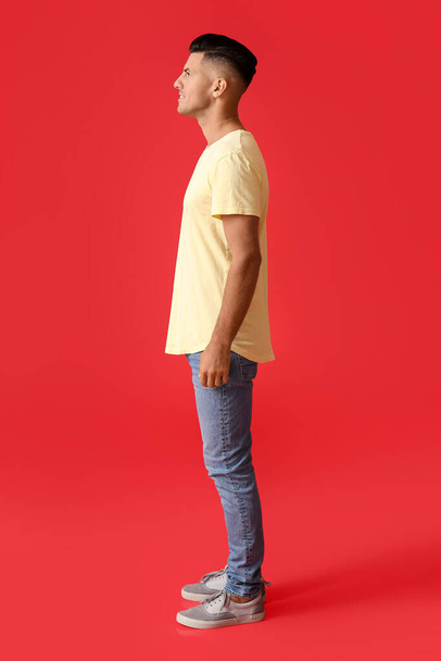Bello giovane uomo in elegante t-shirt su sfondo di colore - Foto, immagini