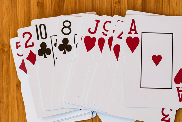 Speelkaarten van dichtbij, geïsoleerd op houten tafel. Casino concept, risico, kans, veel geluk of gokken. - Foto, afbeelding
