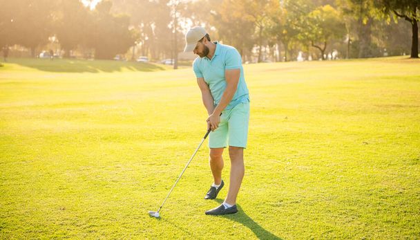 golfista v čepici s golfovou holí. životní styl lidí. sport muž hrát hru na zelené trávě. - Fotografie, Obrázek