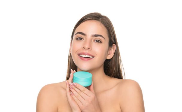 glückliche junge Frau halten Cremedose für Gesichtshaut isoliert auf weißem Hintergrund, Gesichtsbehandlung - Foto, Bild