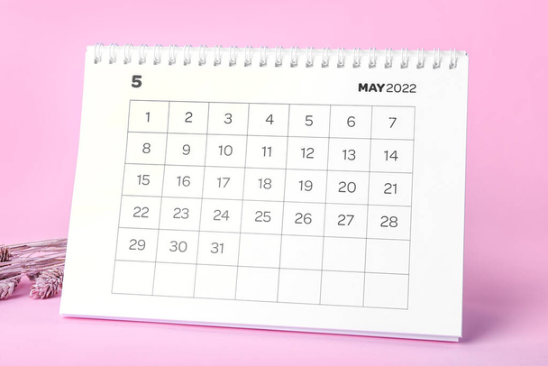 Klassischer Flip-Paper-Kalender für Mai 2022 und Blumen auf farbigem Hintergrund - Foto, Bild