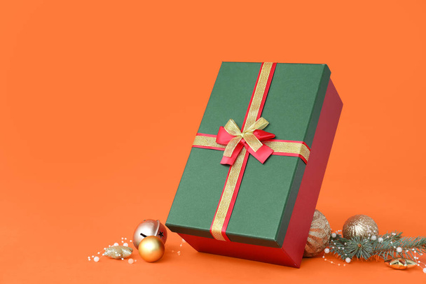 Christmas gift box with balls and fir branch on color background - Fotografie, Obrázek