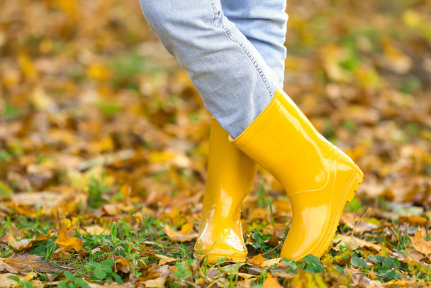 Woman in yellow gumboots in autumn park - Photo, Image